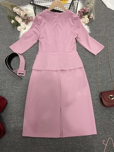 Détail de la robe crayon rose à basque, manches courtes avec ceinture assortie et fente