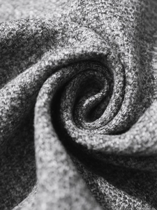 Macro shot of high-quality grey wool blend fabric showing thick twill weave texture