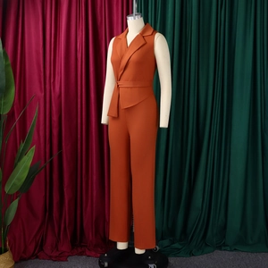 Detail of sashed waist and notched lapel on this sleeveless orange jumpsuit
