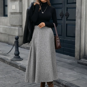 Chic grey tweed high-waisted A-line midi skirt styled with a leather jacket in a city street