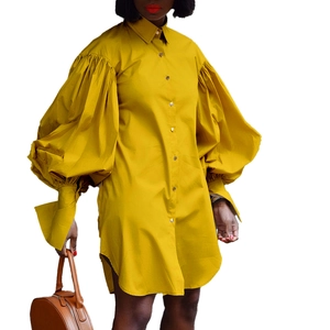 Détail d'une robe chemise jaune moutarde avec manches bouffantes et boutonnage à l'avant