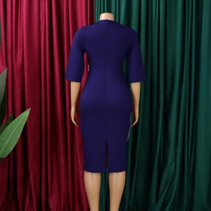 Back view of a navy blue midi dress with pleated sleeves and a functional back slit detail