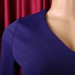 Detail shot of purple V-neck dress featuring premium pleated texture and fine stitching