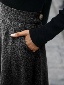 Close-up of grey wool A-line skirt featuring side pocket and amber button detail