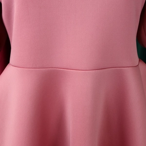 Close-up detail of the waist stitching and peplum hem on this elegant pink dress