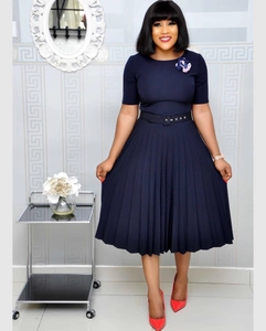 Elegant navy blue pleated dress with waist belt and a floral brooch detail
