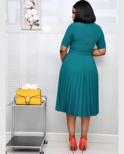 Detail of dark green pleated dress back showing waist belt and zipper closure