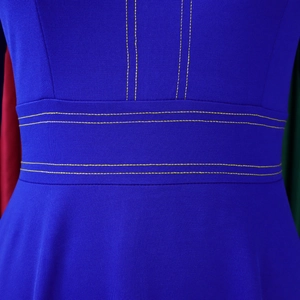 Dettaglio della vita di un abito blu con doppie cuciture gialle a contrasto