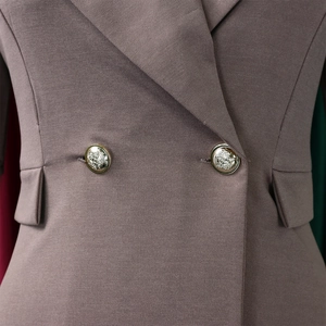 Détail des boutons dorés à tête de lion sur un blazer classique avec poches à rabat
