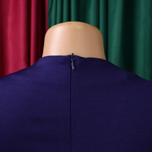 Close-up of invisible zipper closure on the back of a purple pleated dress with fine texture