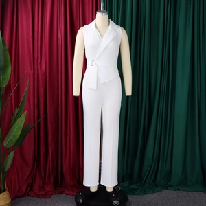Detail of white sleeveless jumpsuit featuring a notched lapel and waist belt with buckle