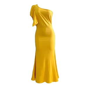 Detail of elegant one-shoulder mustard yellow dress with decorative ruffled shoulder and mermaid hem