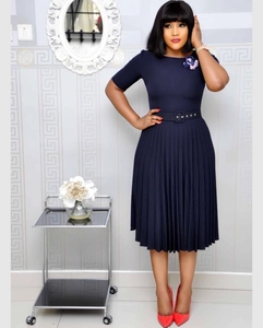 Detail view of navy blue pleated dress with floral accent and waist belt