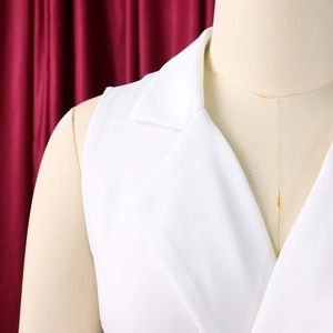 Close-up of white sleeveless suit collar and shoulder detail on a tailored jumpsuit