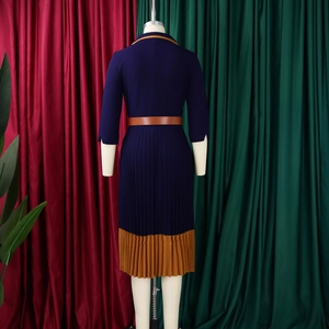 Detail eines eleganten zweifarbigen Plisseekleids mit dunkelblau-braunem Kontrastgürtel