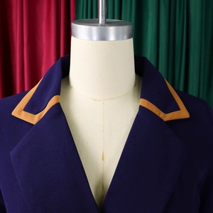 Detail eines dunkelblauen Blazers mit gelber Paspel am Revers und feiner Webstruktur