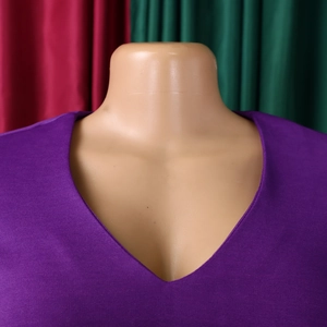 Detail of deep V-neckline on purple pleated dress with fine knitted fabric texture