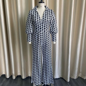 Detail of long sleeve houndstooth wide leg jumpsuit with V-neck and puff sleeves