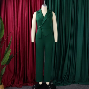 Detail of dark green sleeveless jumpsuit showing blazer collar and belted waist design