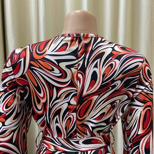 Detail view of the back zipper and waist tie on the colorful African print long sleeve jumpsuit