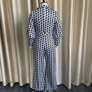 Back view of a chic black and white houndstooth jumpsuit on a mannequin in a studio