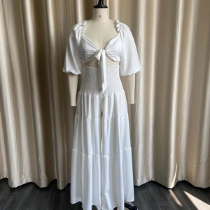 Detail of white two-piece set featuring lace-up crop top and tiered wide leg pants