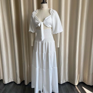 Detail of white two-piece set with tie-front crop top and high waist long skirt