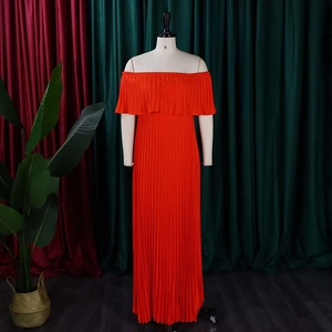 Détail de la robe longue plissée à épaules dénudées en orange vif sur un mannequin de studio