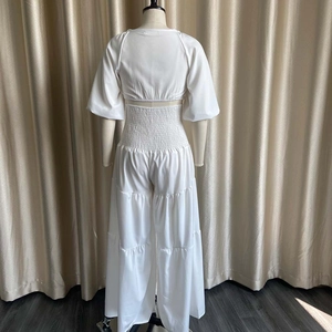 Detail of white two-piece set featuring a back smocked crop top and elastic high waist pants