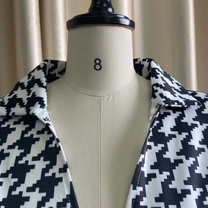Detail of the V-neck lapel and classic houndstooth pattern on a straight jumpsuit