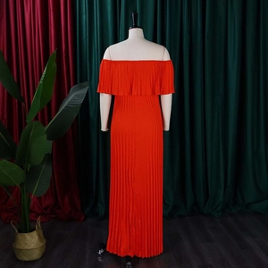 Détail de robe maxi rouge à épaules dénudées avec tissu plissé élégant et décolleté à volants