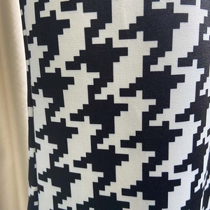 Detailed macro shot of classic black and white houndstooth fabric pattern on jumpsuit