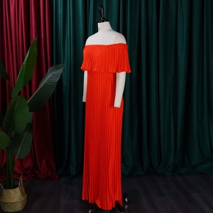 Détail d'une robe rouge plissée à épaules dénudées avec mousseline et volant au col