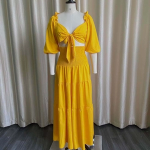 Detailed close-up of bright yellow crop top with puff sleeves and layered summer skirt