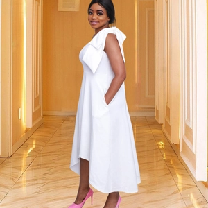 Robe blanche élégante sans manches avec un grand nœud à l'épaule et un ourlet asymétrique