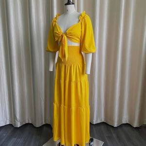 Detail of yellow crop top with tie-front V-neck and ruffled puff sleeves on a mannequin