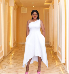 Détail de la robe blanche à une épaule avec jupe asymétrique haute et basse fluide