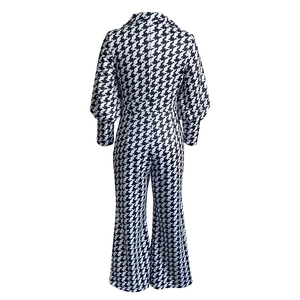 Detail view of back structure on houndstooth jumpsuit featuring puff sleeves and wide leg cut