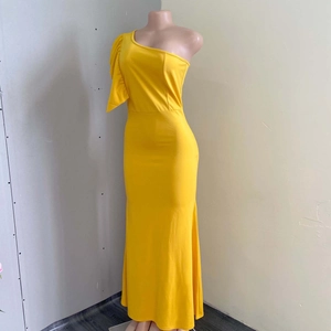Detail of ruffled one-shoulder sleeve and bright yellow fabric on this evening gown