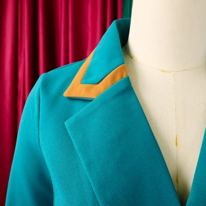 Detail des blaugrünen Blazers mit kontrastierendem orangefarbenem Patch und feinem Stoff