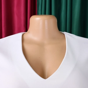 Detailed view of the elegant white V-neckline and pleated texture of this African dress