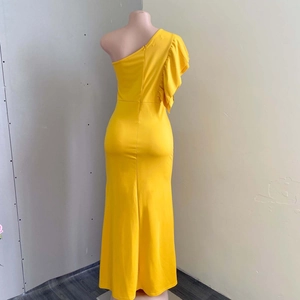 Detailed back view of yellow one-shoulder gown featuring hidden zipper and ruffles