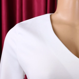 Detailed close-up of V-neckline and pleat texture on white African style dress