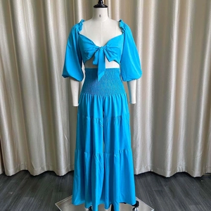 Detail of blue two-piece set featuring smocked high waist and layered wide-leg pants design