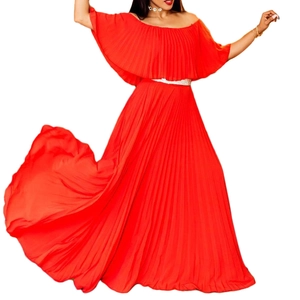 Détail macro d'une robe maxi plissée rouge à épaules dénudées avec une fine ceinture argentée