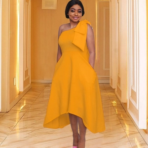 Détail d'une élégante robe jaune à une épaule avec grand nœud et ourlet asymétrique