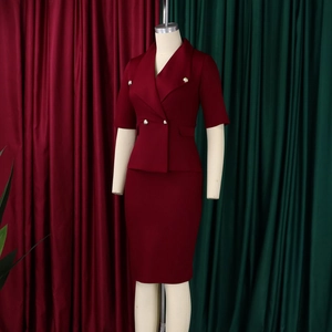 Détail d'un tailleur rouge foncé avec boutons dorés à double boutonnage et jupe crayon