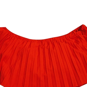 Détail du tissu en mousseline plissée rouge avec texture dense et taille élastique