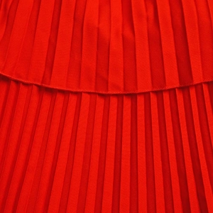 Détail du tissu plissé rouge avec texture double couche et coutures de bordure fines