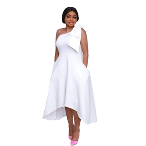 Détail de la robe blanche asymétrique avec nœud géant et ourlet queue de pie élégant